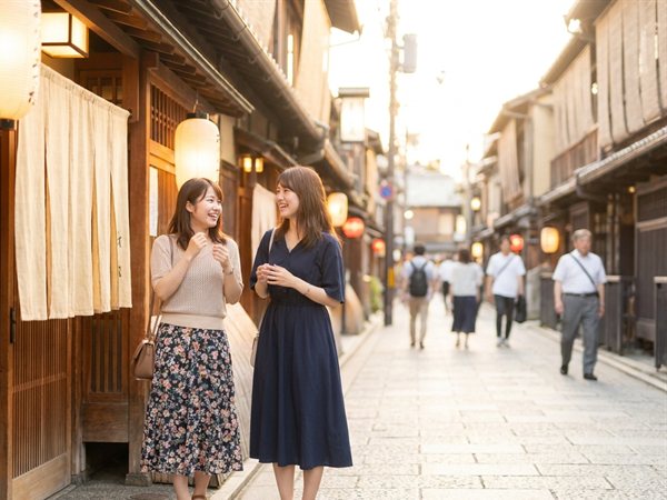 夕方の京都の飲食店街で待ち合わせをする様子